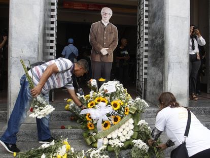 Personas colocan flores frente a la imagen de Botero en un homenaje en el Museo de Antioquia en Medellín (Colombia), este viernes.