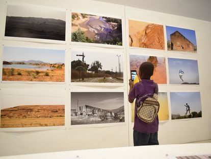 Un niño hace una fotografía de las obras que se exhiben en los Encuentros de Bamako–Bienal Africana de Fotografía en Bamako, Malí.