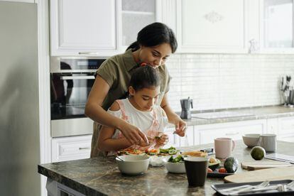 Una madre cocina con su hija.