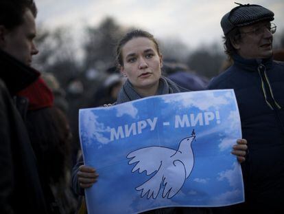 Una mujer sujeta un cartel donde se lee 'Paz en el Mundo' durante una protesta en Moscú (Rusia).