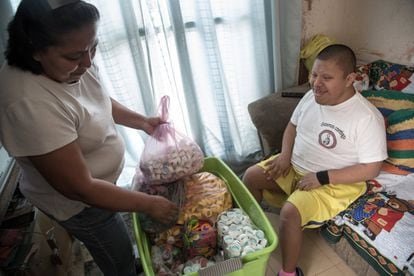Asela Guadalupe López, madre de Víctor, un chico con síndrome de Down de 27 años, muestra las tapas de envases de colores con las que a Víctor le gusta jugar. Estado de México.