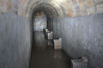 Un dels túnels inundats amb aigua que conserva els murs amb bancs perquè les persones es poguessin asseure durant el bombardeig.