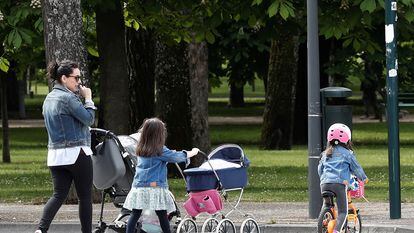 Una madre pasea con sus dos hijos hacia el parque de la Ciudadela de Pamplona.