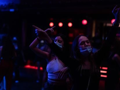 Dos jóvenes bailan en la Sala Apolo (Barcelona) en la noche de reapertura del ocio nocturno, este jueves. / [ALBERT GARCIA]