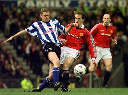 Phil Neville pugna por un balón con Andy Booth, del Sheffield, en un partido entre ambos equipos de 1999.