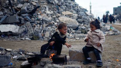 Dos niños en una calle de Jan Yunis, rodeados de edificios destrozados por los ataques israelíes.