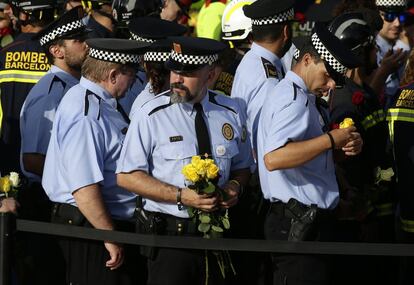 Policías de la guardia urbana con flores durante la protesta por los ataques.