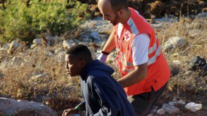 Un efectivo de Cruz Roja atiende a un inmigrante que intent&oacute; cruzar el Estrecho en moto de agua. 