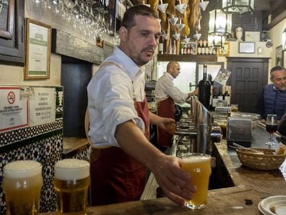 Un camarero sirve cervezas en un bar de Sevilla.