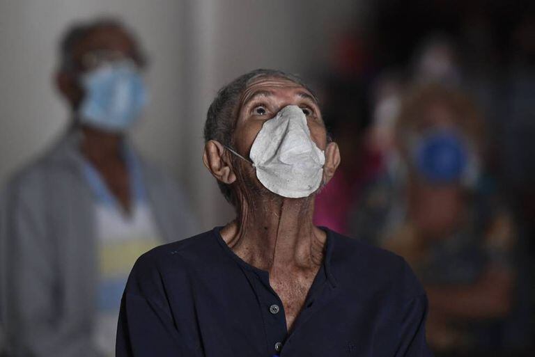 Un hombre con mascarilla reza en una iglesia de Caracas, en Venezuela.