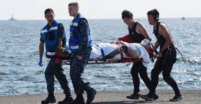 Militares estadounidenses y japoneses evacúan a uno de los marineros heridos tras la colisión.