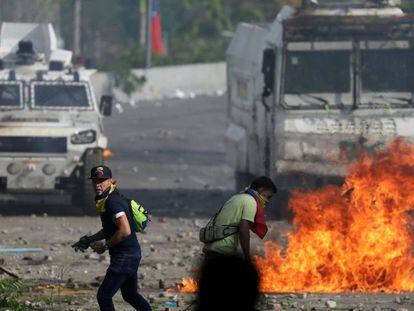 Opositores de Maduro frente a tanquetas militares, este miércoles.