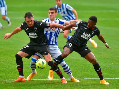 Kike García (izquierda) protege el balón ante Barrenetxea (centro) este domingo en Anoeta.