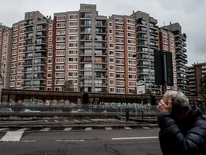 Un hombre pasa ante un edificio de viviendas en la localidad lombarda de Sesto San Giovanni.