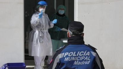 Varios sanitarios efectúan pruebas para detectar el coronavirus en la parte exterior del pabellón de la Casa de Campo, Madrid.
