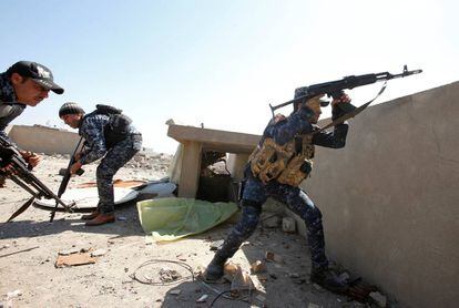 Un pollic&iacute;a federal iraqu&iacute; dispara su rifle en un distrito de la ciudad vieja de Mosul, este domingo