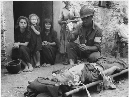 Un soldado estadounidense herido en Sicilia recibe plasma ante la mirada de civiles italianos.