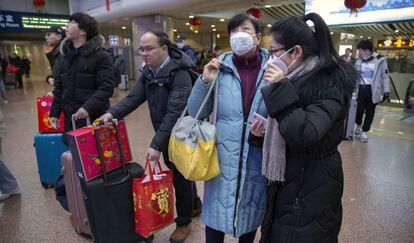 Un grupo de viajeros usa este martes mascarillas en una estación ferroviaria en Pekín.