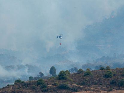 Un helicóptero trabaja en las tareas de extinción del incendio en Los Guájares (Granada), este domingo.