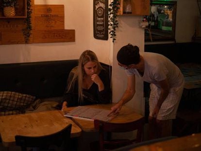 Una camarera atiende a una mujer en un bar de Barcelona