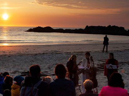 Tres miembros del Cuarteto Sonoro tocan en la medianoche del martes en la playa de Gimsøy. 