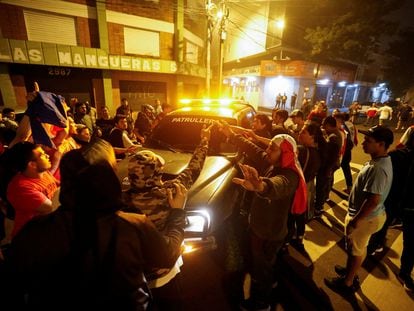 Seguidores del excandidato presidencial Paraguayo Cubas atacan un coche de la policía durante una protesta en Asunción contra el resultado electoral, el 1 de mayo de 2023.