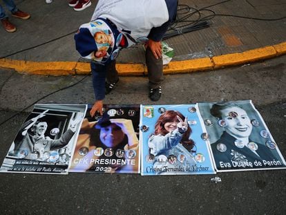 Un hombre coloca insignias con la imagen de Cristina Fernández sobre carteles afuera de la casa de la vicepresidenta, el 2 de septiembre de 2022, en Buenos Aires.
