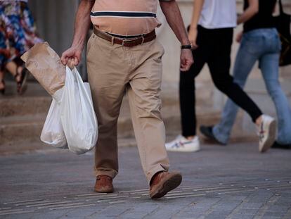 Un hombre carga con las bolsas de la compra, este martes en Valencia.