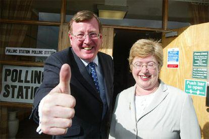 David Trimble, líder del Partido Unionista del Ulster, saluda a los fotógrafos junto a su esposa, Daphne, frente a su colegio electoral de Lisburn (Irlanda del Norte). La normalización definitiva del Ulster será uno de los retos principales del ganador de las elecciones en Reino Unido.