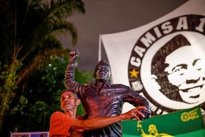 A man in front of the statue of Pelé, in Santos, a coastal municipality in the State of São Paulo (Brazil).