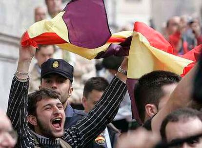 Un joven despliega una bandera republicana en protesta por la presencia de los Reyes en Oviedo.