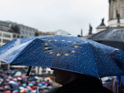 Un hombre sostiene un paraguas con la bandera de la UE