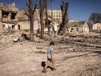 Un niño camina frente a una colegio destruido en la ciudad de Yitómir, en el noroeste de Ucrania.