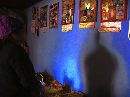 Lucia Santos Coyoi mira las fotos de su hijo colgadas en la pared de su casa.