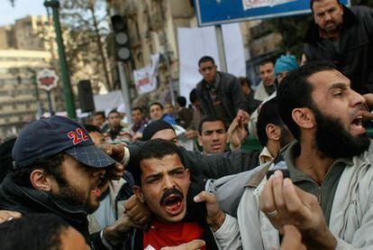 Un sospechoso de ser agente de las fuerzas de seguridad egipcias es zarandeado por la multitud contraria a Mubarak