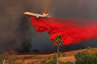 Un avión DC-10 deposita un compuesto retardante de fuego para evitar que el incendio vaya a más en el condado de Orange (California).