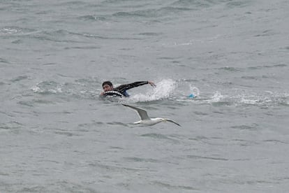 Un hombre nada rumbo a Ceuta, esta mañana, junto a la frontera y la playa del Tarajal, en Ceuta.