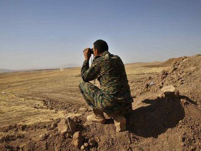Un peshmerga kurdo observa a tanques del Estado Isl&aacute;mico en Irak.