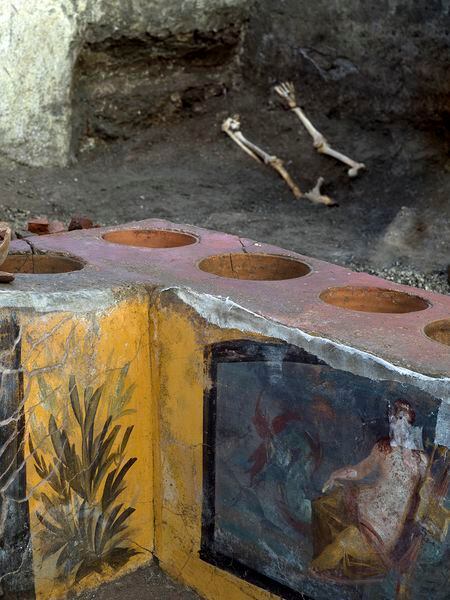 Detalle de la barra del termopolio de Pompeya, con restos humanos al fondo.