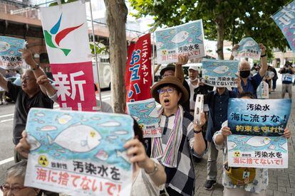 A group of protesters hold signs against the water spill from the nuclear power plant in front of the Tokyo Electric Power Company (TEPCO) headquarters in Tokyo, Japan, on Thursday.