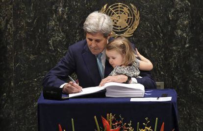 US Secretary of State John Kerry signs the Paris Agreement with his granddaughter during the signing ceremony at the United Nations headquarters in New York.