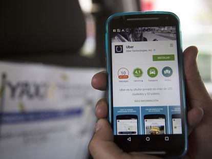Un hombre sostiene un celular que muestra la aplicación de Uber en Ciudad de México.