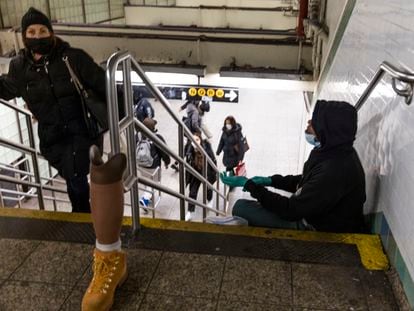Un indigente pide ayuda en una estación de metro de Nueva York.
