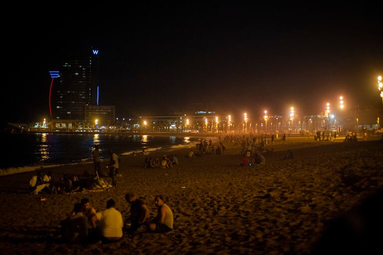 Jóvenes de botellón en la playa de la Barceloneta, el viernes por la noche.