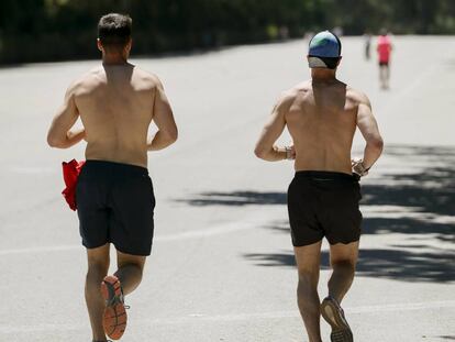 Dos hombres corren en el parque del Retiro de Madrid.