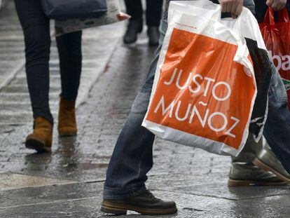 Un grupo de personas camina con bolsas de diversos establecimientos el primer d&iacute;a de rebajas en Valladolid.