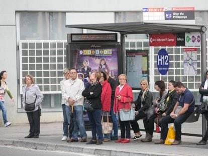 Persones esperant en una parada d'autobús.