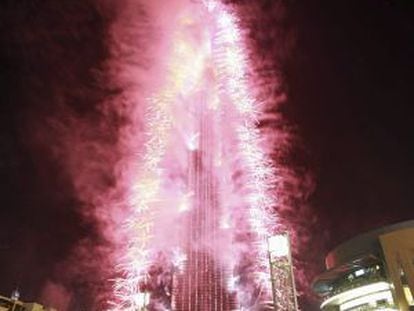 Varias personas observan los fuegos articiales para celebrar que Dubai fue elegida sede para acoger la Exposición Universal en 2020, frente al edificio Burj Khalifa, Dubai, Emiratos Árabes.