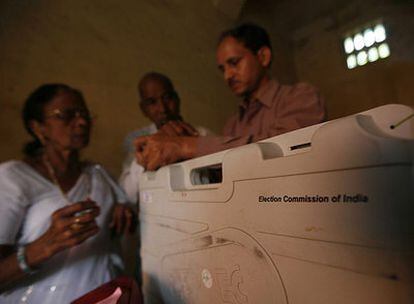 Un miembro de mesa sella una máquina de votación electrónica al cierre de los comicios en un centro electoral en India