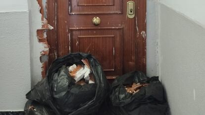 Vista de la puerta del piso en el que se encontraba la fallecida. Las bolsas guardan los ladrillos que tapiaban la entrada.